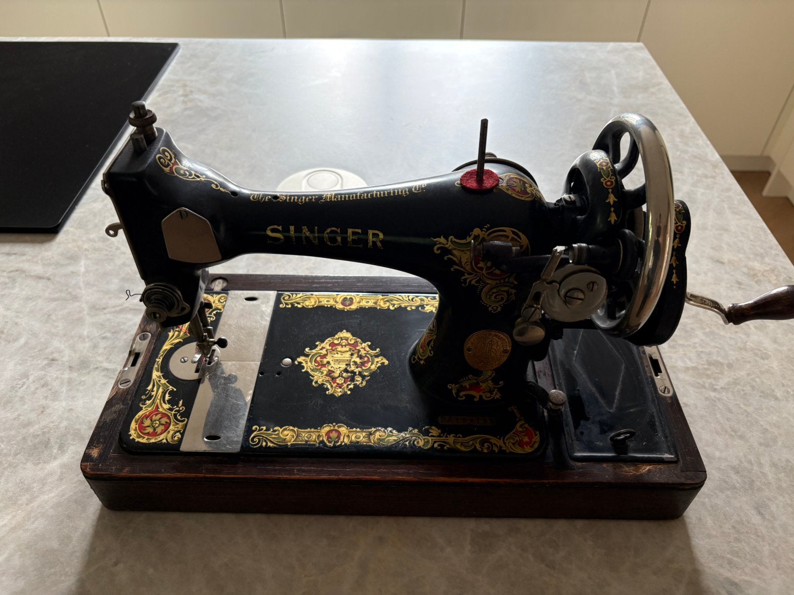 Antieke Singer naaimachine met handzwengel en houten kap, Ophalen