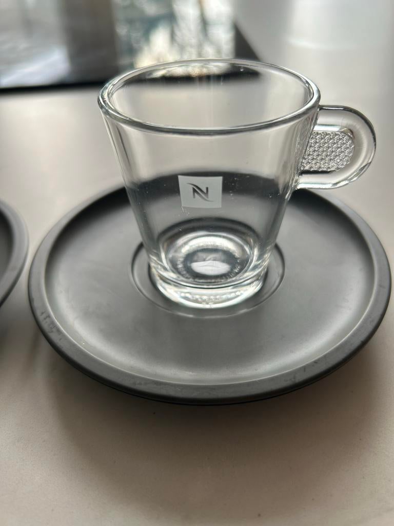 Nespresso kop en schotel set + lepel, Gebruikt, Ophalen of Verzenden, Glas, Effen