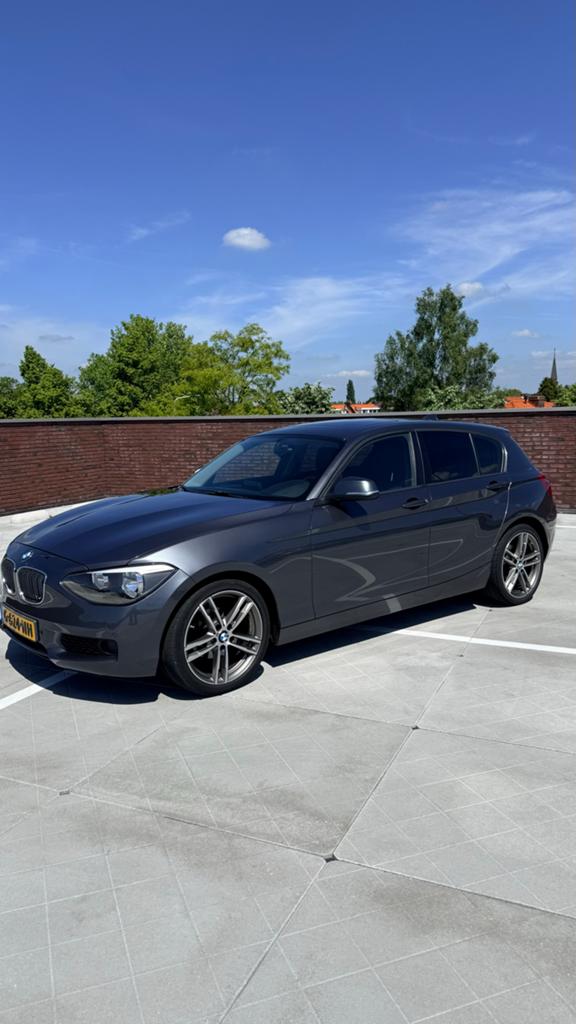 BMW 1-Serie 116I 100KW 5DR Aut8 2012 Grijs, Auto's, BMW, Zwart, 4 cilinders, Leder, 1200 kg