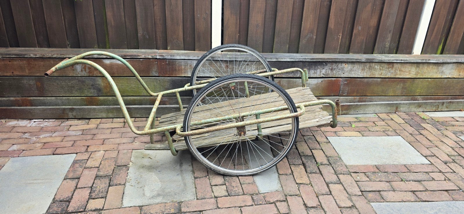 Oude handkar met houten laadbak en fietswielen, Ophalen