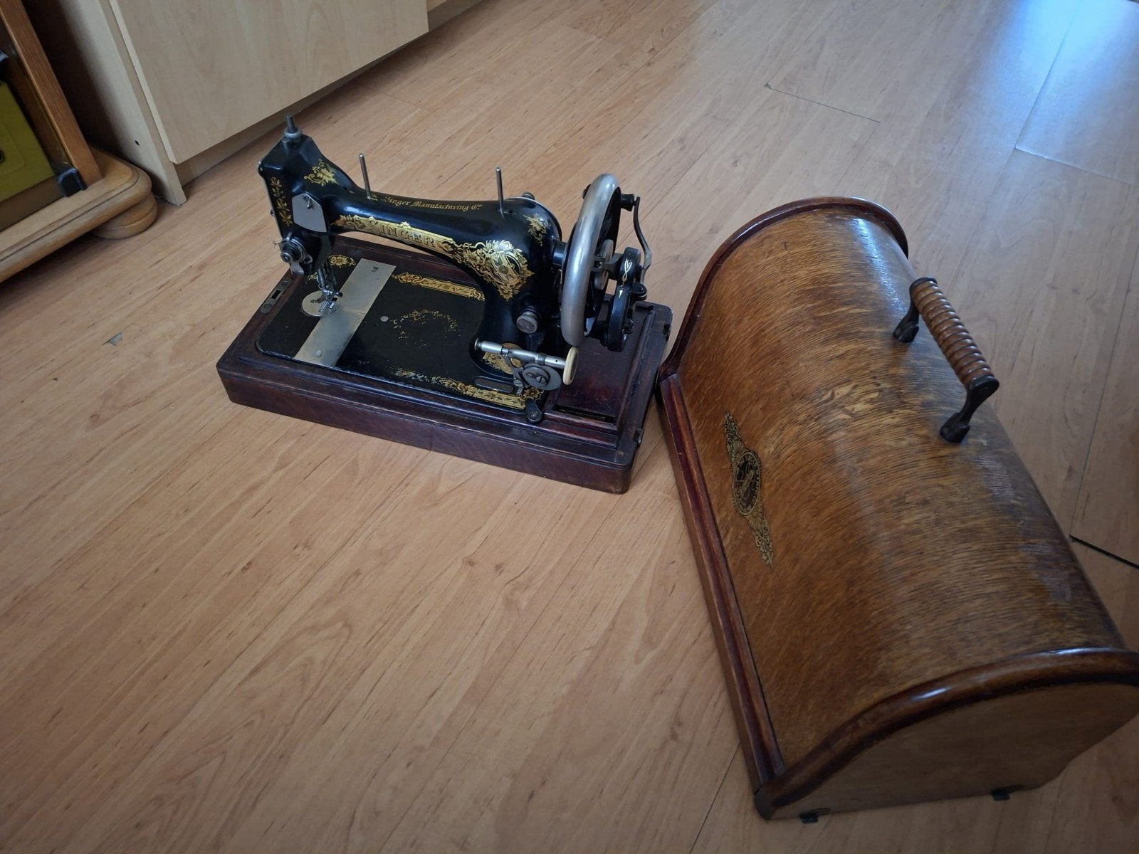 Oude Singer naaimachine in houten bak, Ophalen