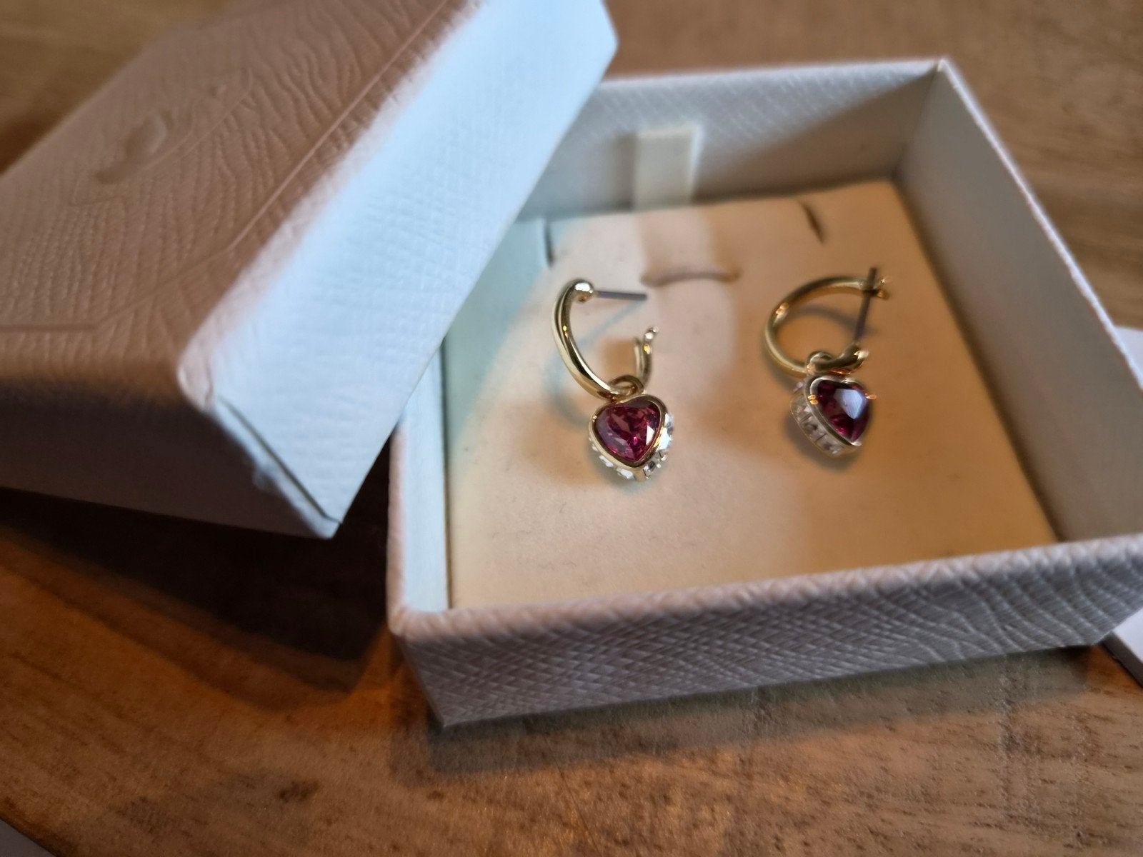 Swarovski oorbellen goud met donkerroze hartjes hanger., Hangers, Ophalen of Verzenden, Zo goed als nieuw, Goud
