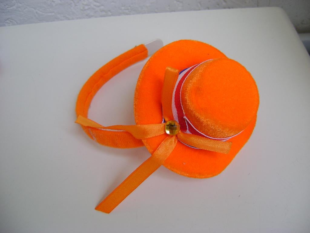 oranje hoedje op diadeem met strikje en rood/wit blauwe rand, Ophalen of Verzenden, Zo goed als nieuw, 122 t/m 128, Meisje