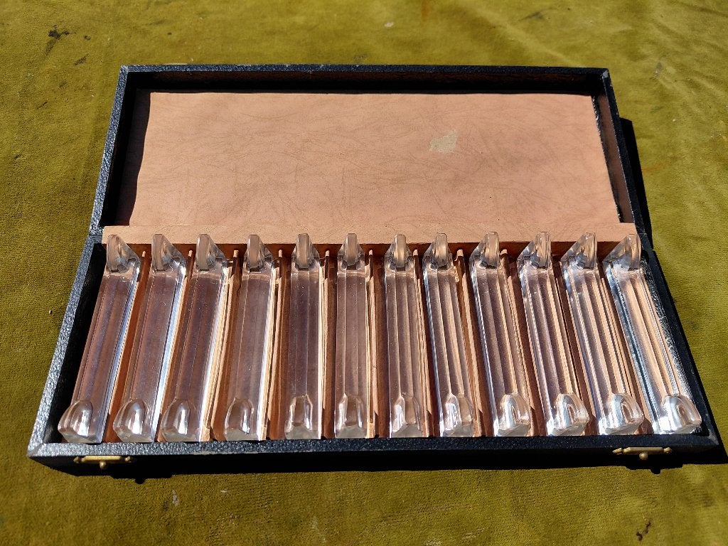Antieke cassette met 12 glazen messenleggers., Verzenden