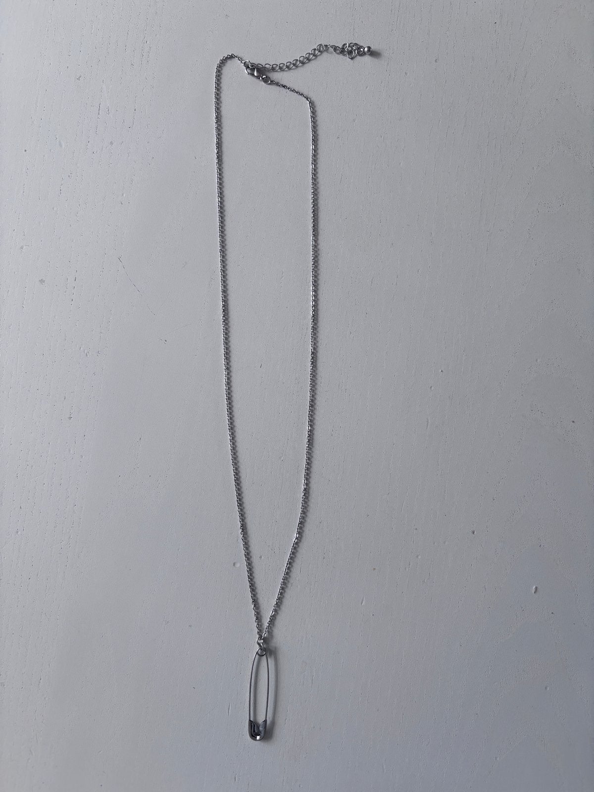 Zilverkleurige ketting met veiligheidsspeld hanger, Gebruikt, Ophalen of Verzenden, Zilver, Overige materialen
