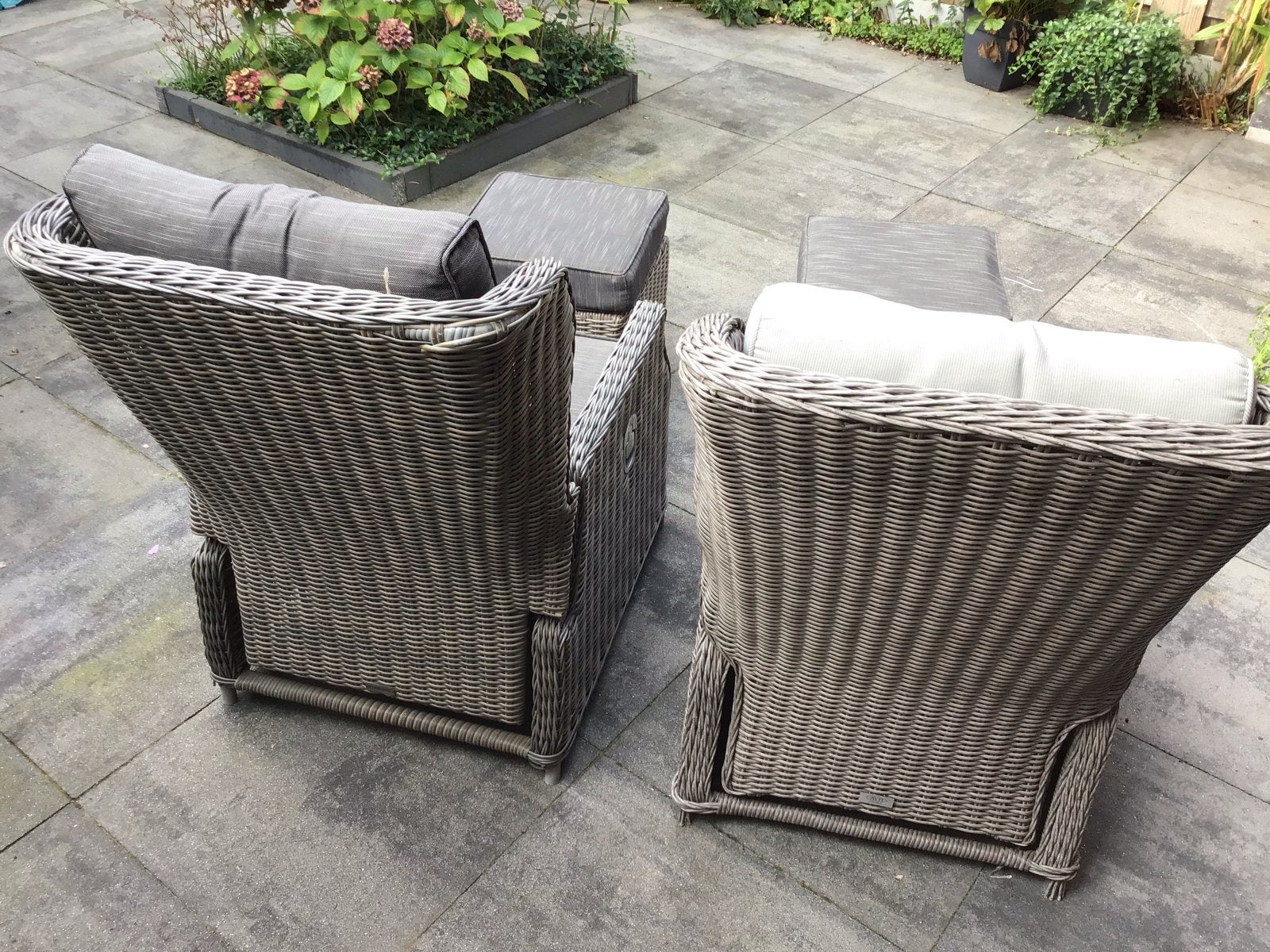 2x Wicker tuinstoelen met voetenbankjes en kussens