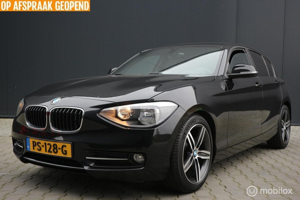 BMW 1-serie 116i Sport AIRCO-ECC/NAVIGATIE/PDC/TREKHAAK/LMV, 1-Serie, Euro 5, 4 cilinders, Zwart