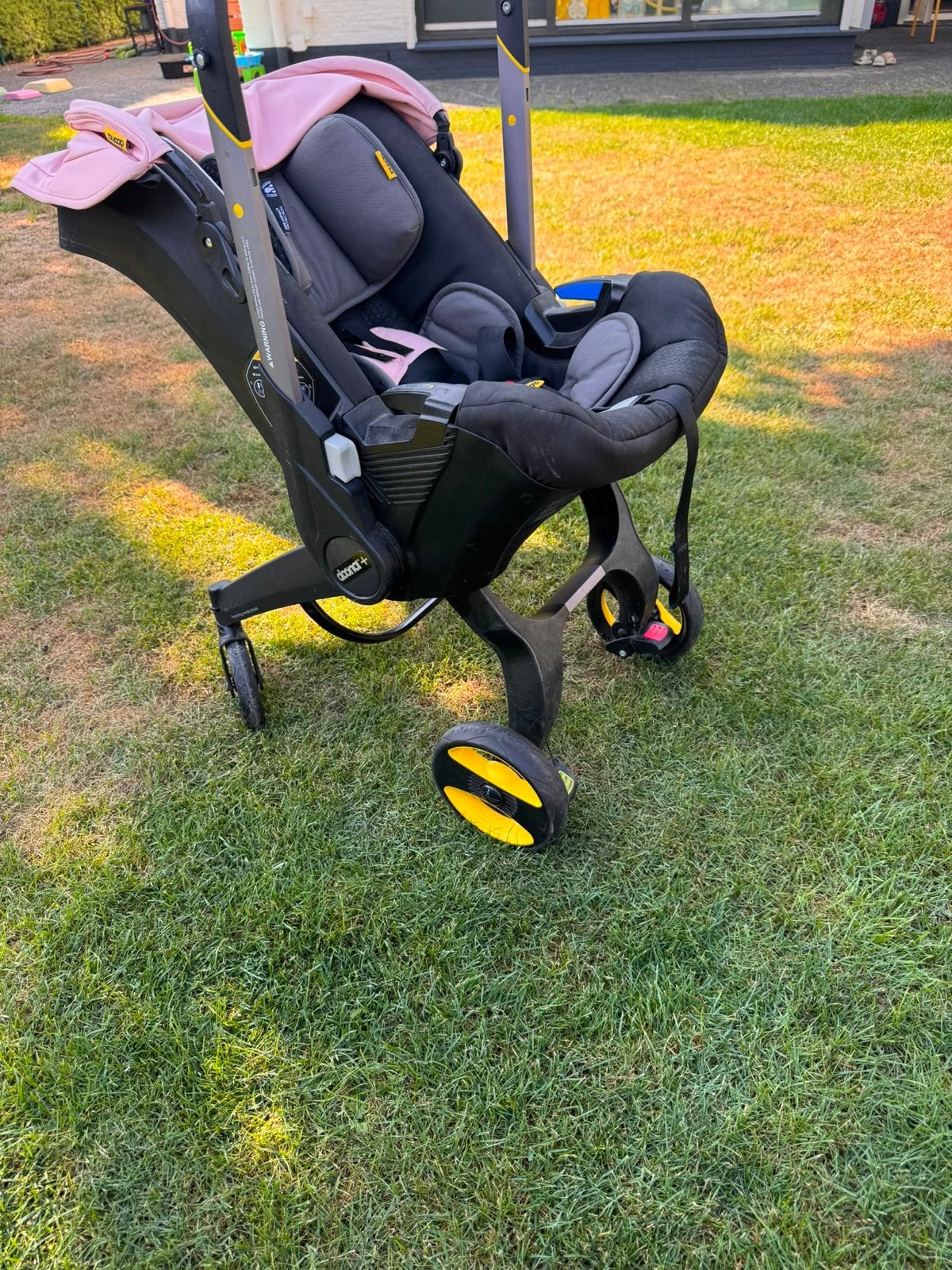 Doona autostoel met geïntegreerde kinderwagen (roze), Autogordel of Isofix, Gebruikt, Zijbescherming, 0 t/m 13 kg
