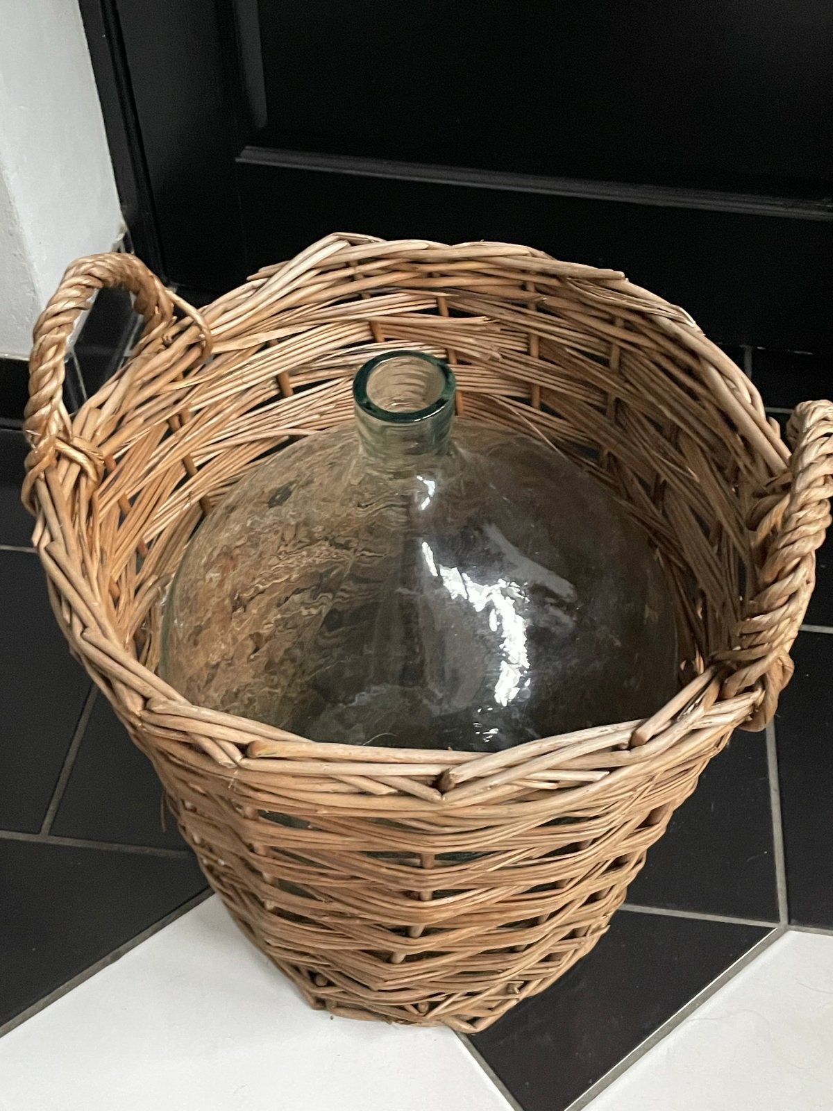Grote glazen fles in rieten mand, Ophalen