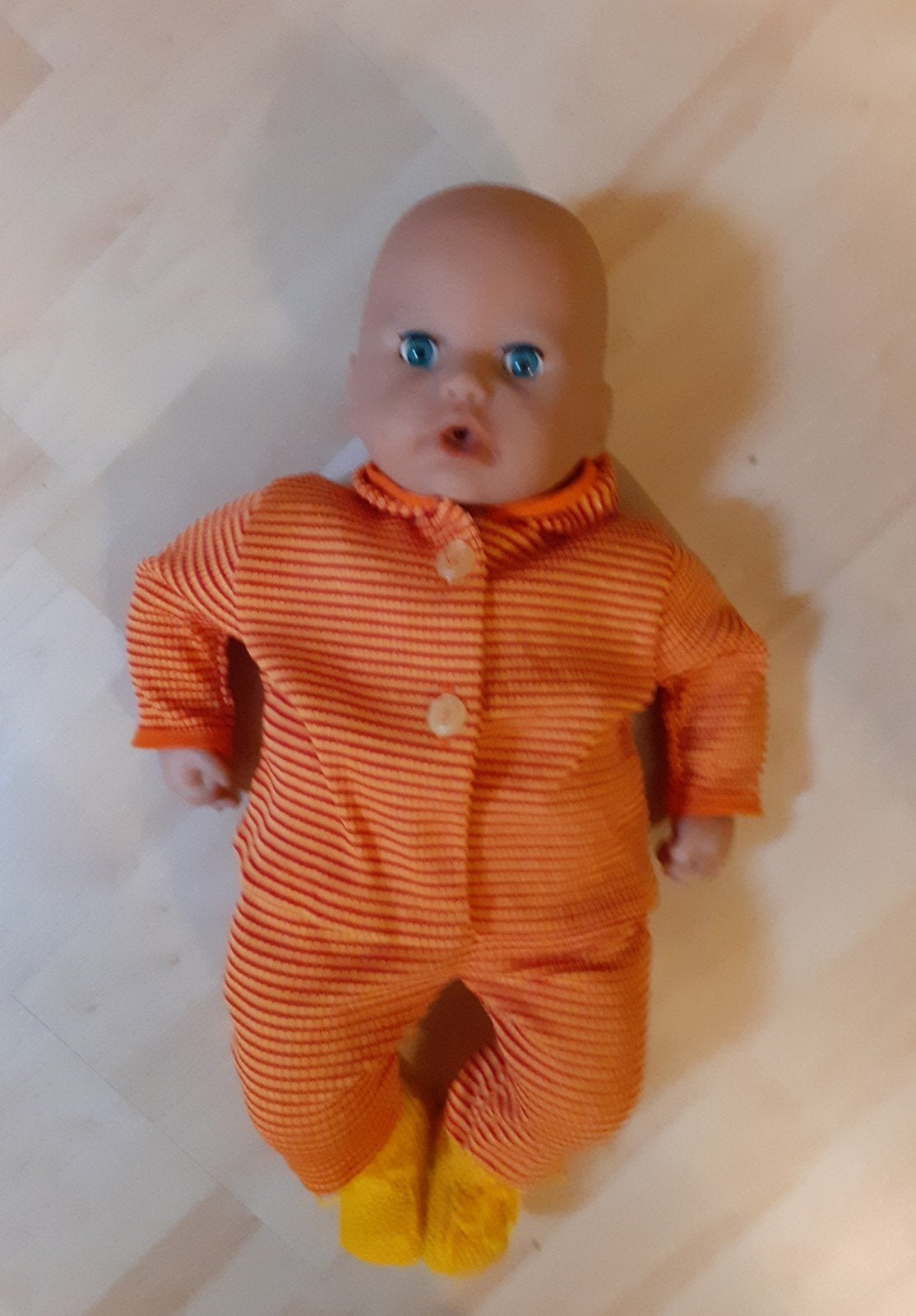Zgan babypop met slaapogen en oranje gestreept pakje, Ophalen of Verzenden