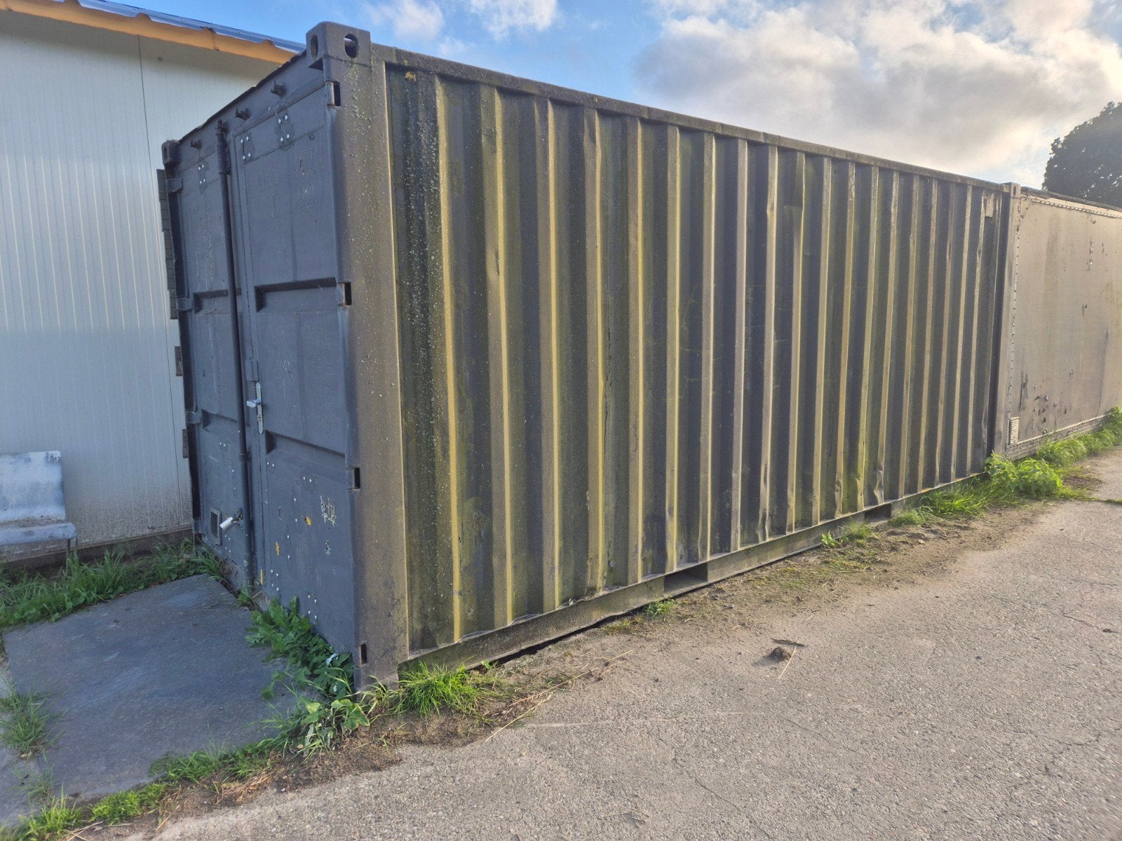 Robuuste zeecontainer met stellingen en werkbank, Ophalen