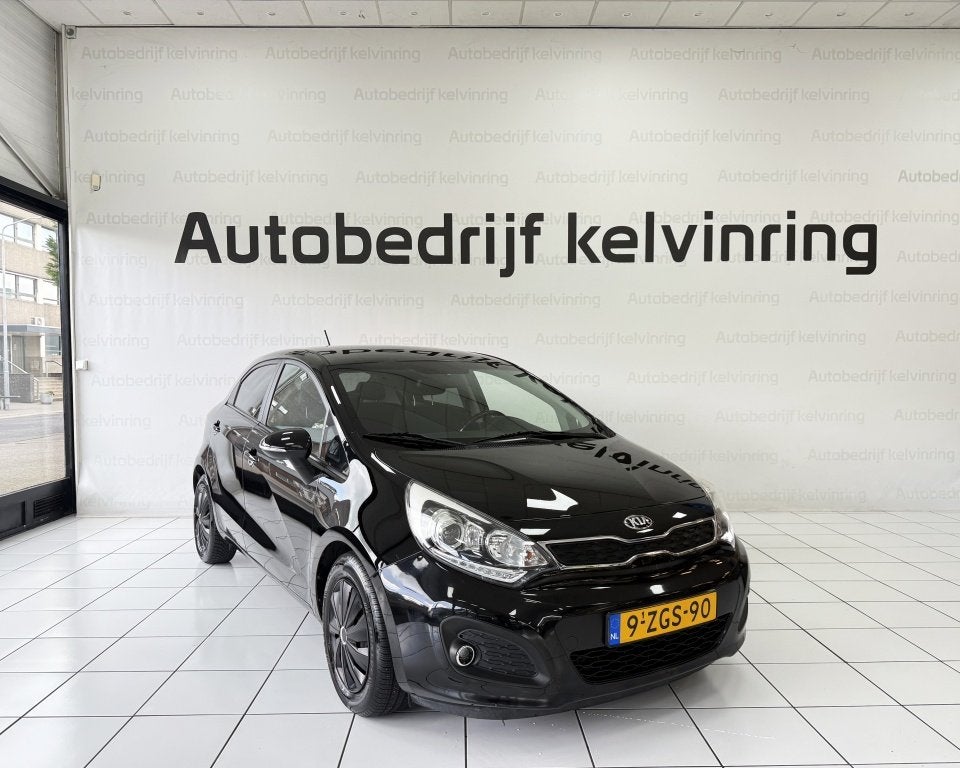Kia Rio 1.2 CVVT Executive Bovag Garantie NAP (bj 2015), 21 km/l, Parkeersensor, 4 cilinders, Zwart