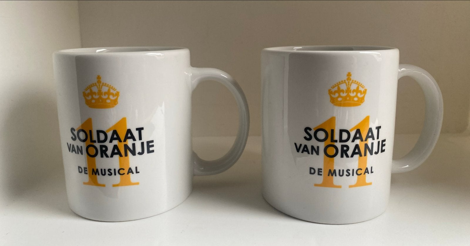 2 Mokken van Soldaat van Oranje De Musical. Hoogte 9 cm, Overige merken, Zo goed als nieuw, Overige stijlen, Aardewerk