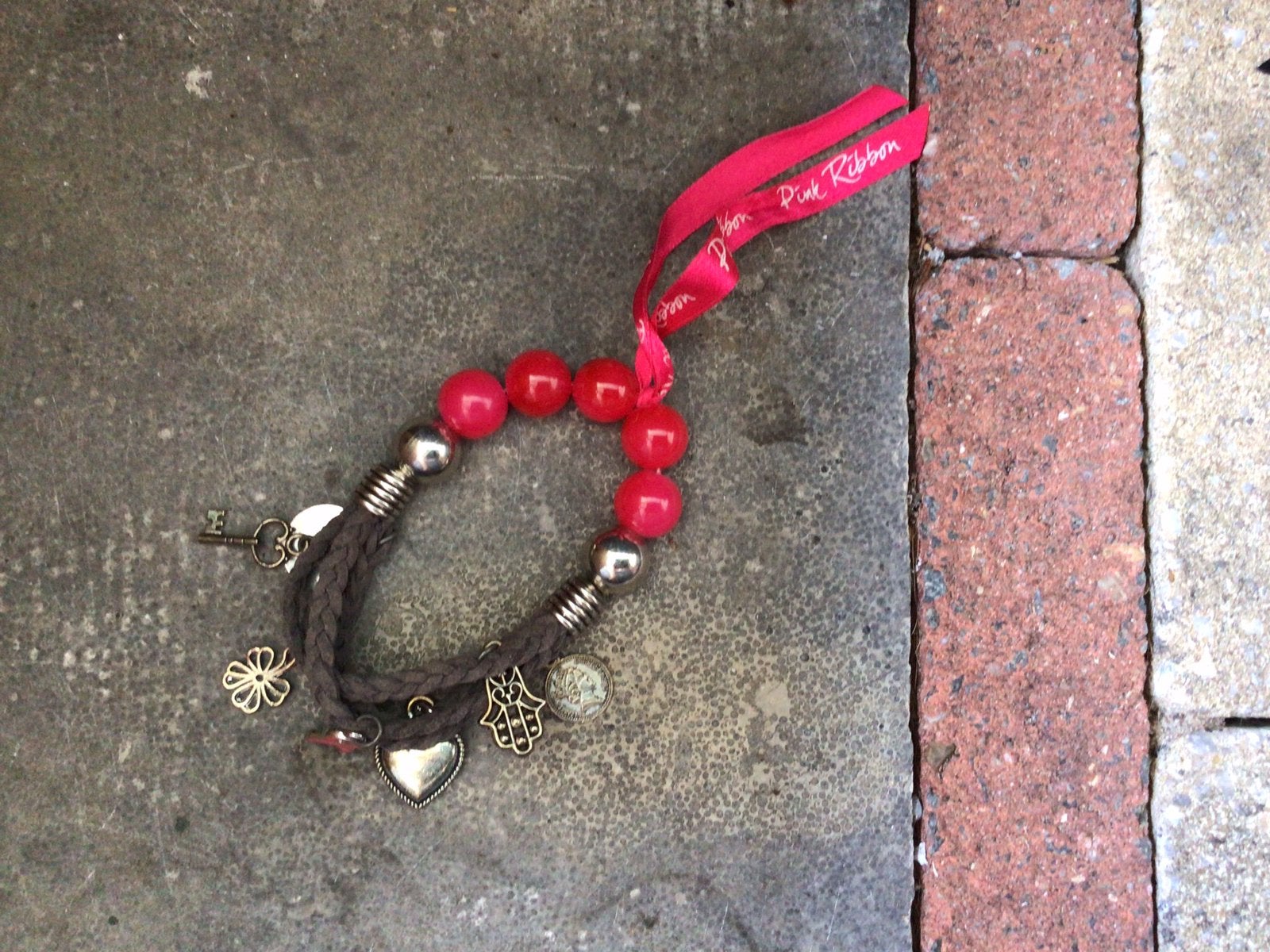 Pink Ribbon armbandje met bedeltjes, Ophalen of Verzenden, Zo goed als nieuw, Roze, Met bedels of kralen