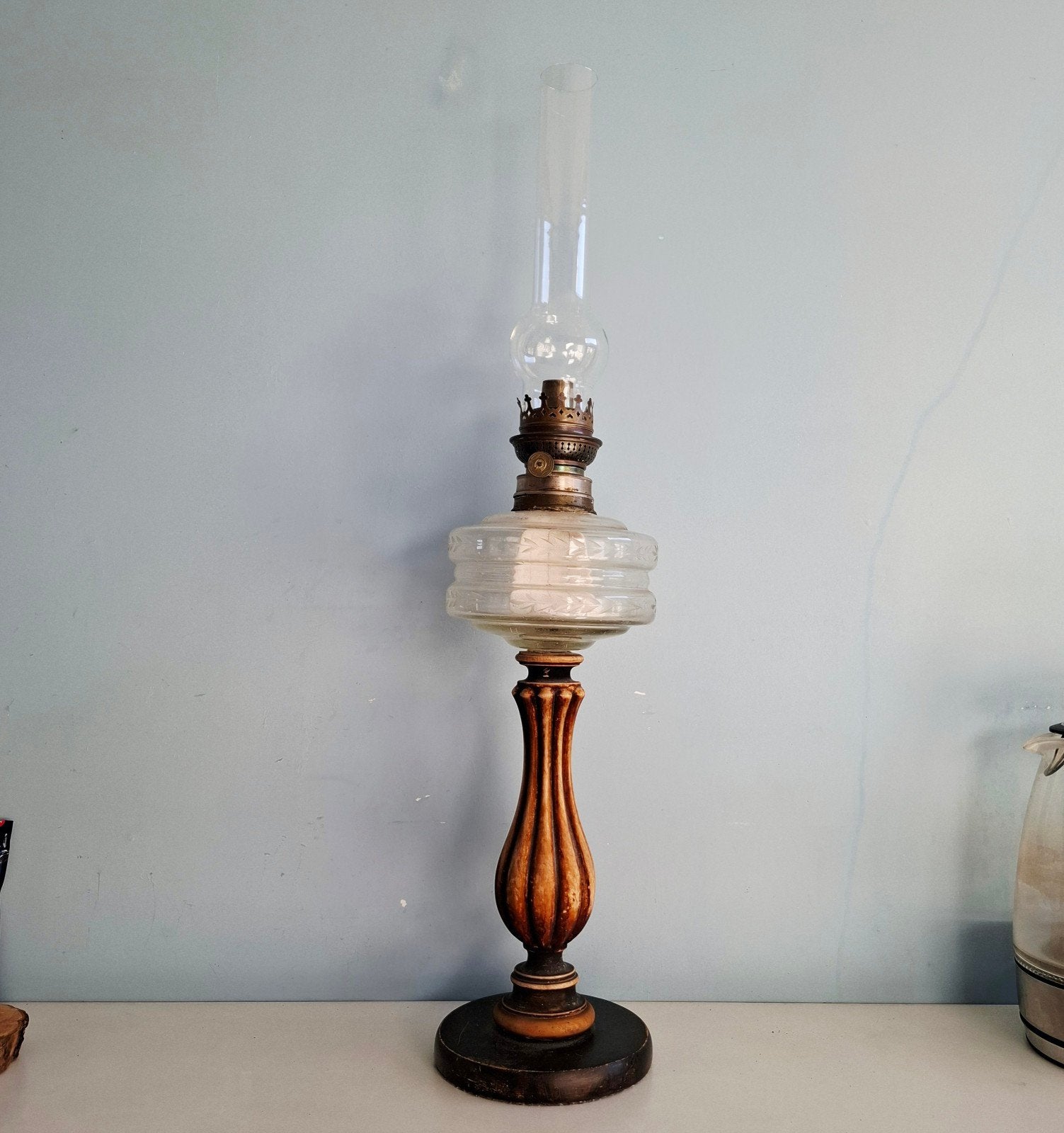 Hoge antieke olielamp met glazen kap en houten voet, Ophalen