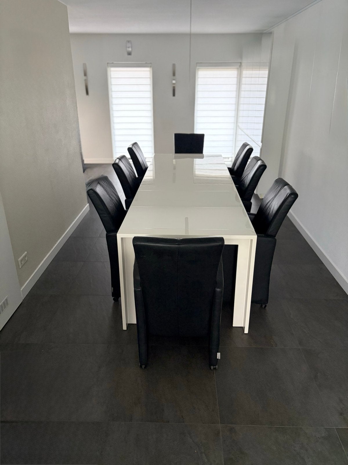 Uitschuifbare eettafel met 8 lederen stoelen op wieltjes
