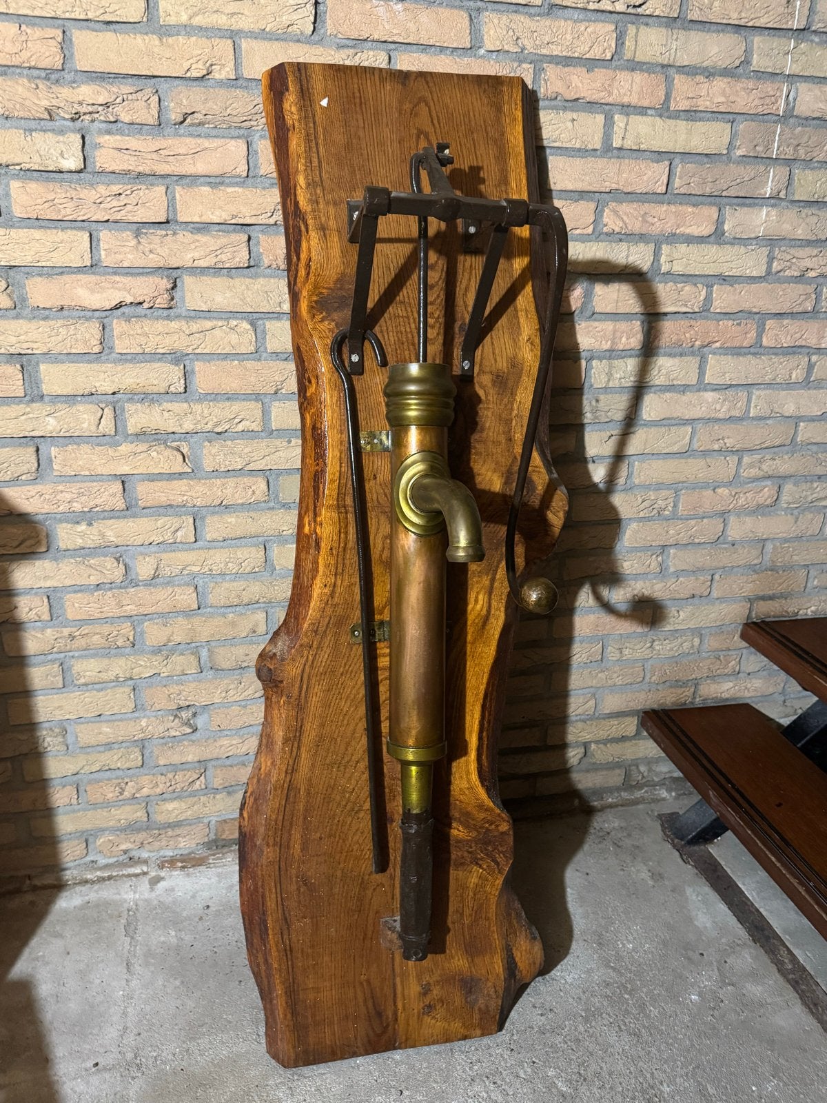 Antieke koperen waterpomp op eiken plank, oude handpomp, Ophalen