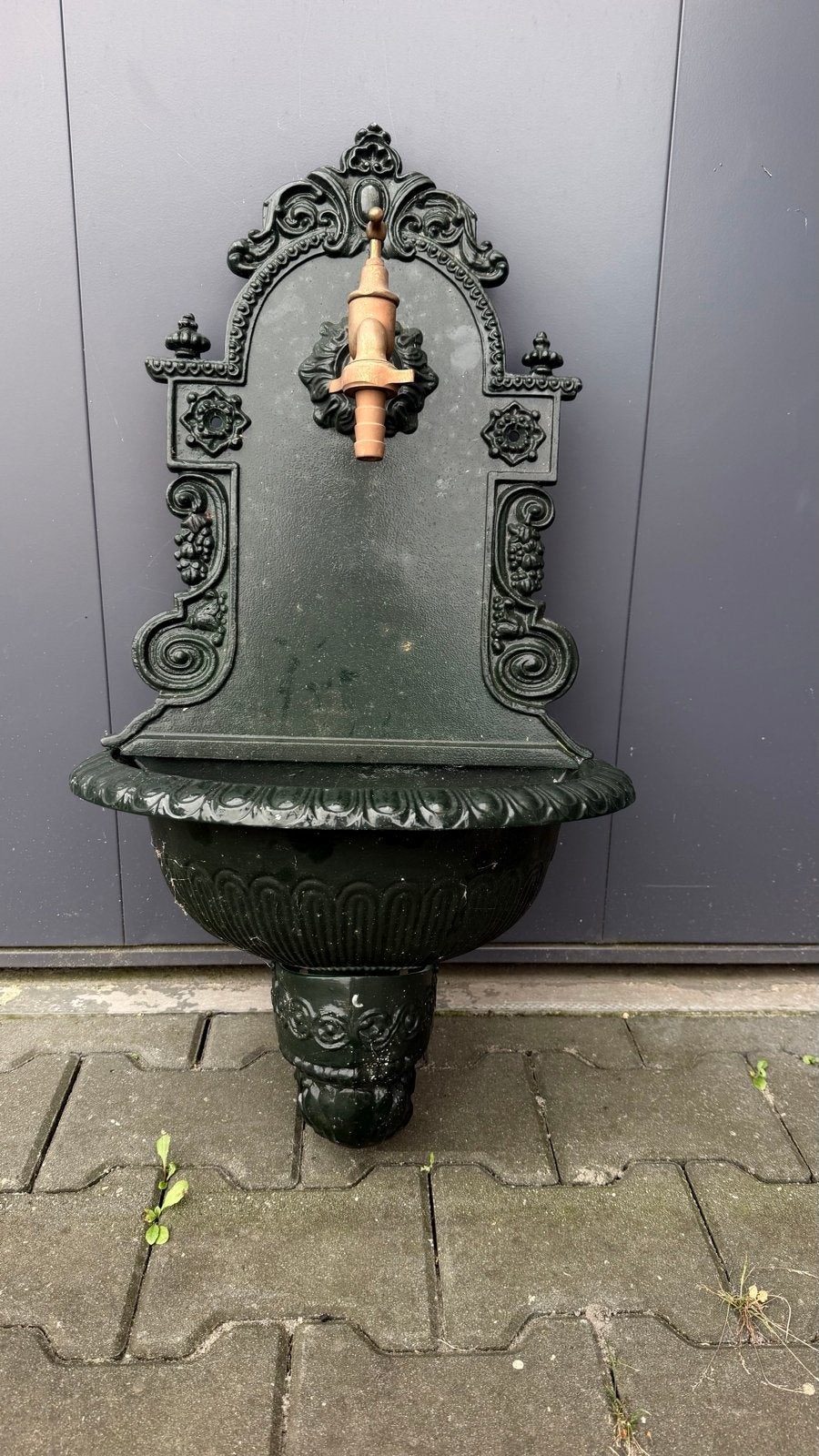 Antieke gietijzeren wandfontein met kraan, Ophalen