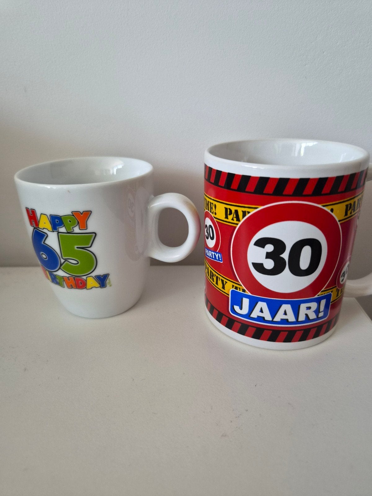 Set van 2 feestelijke mokken: 30 jaar en Happy 65, Huis en Inrichting, Woonaccessoires | Overige, Gebruikt, Steen/keramiek, Meerkleurig