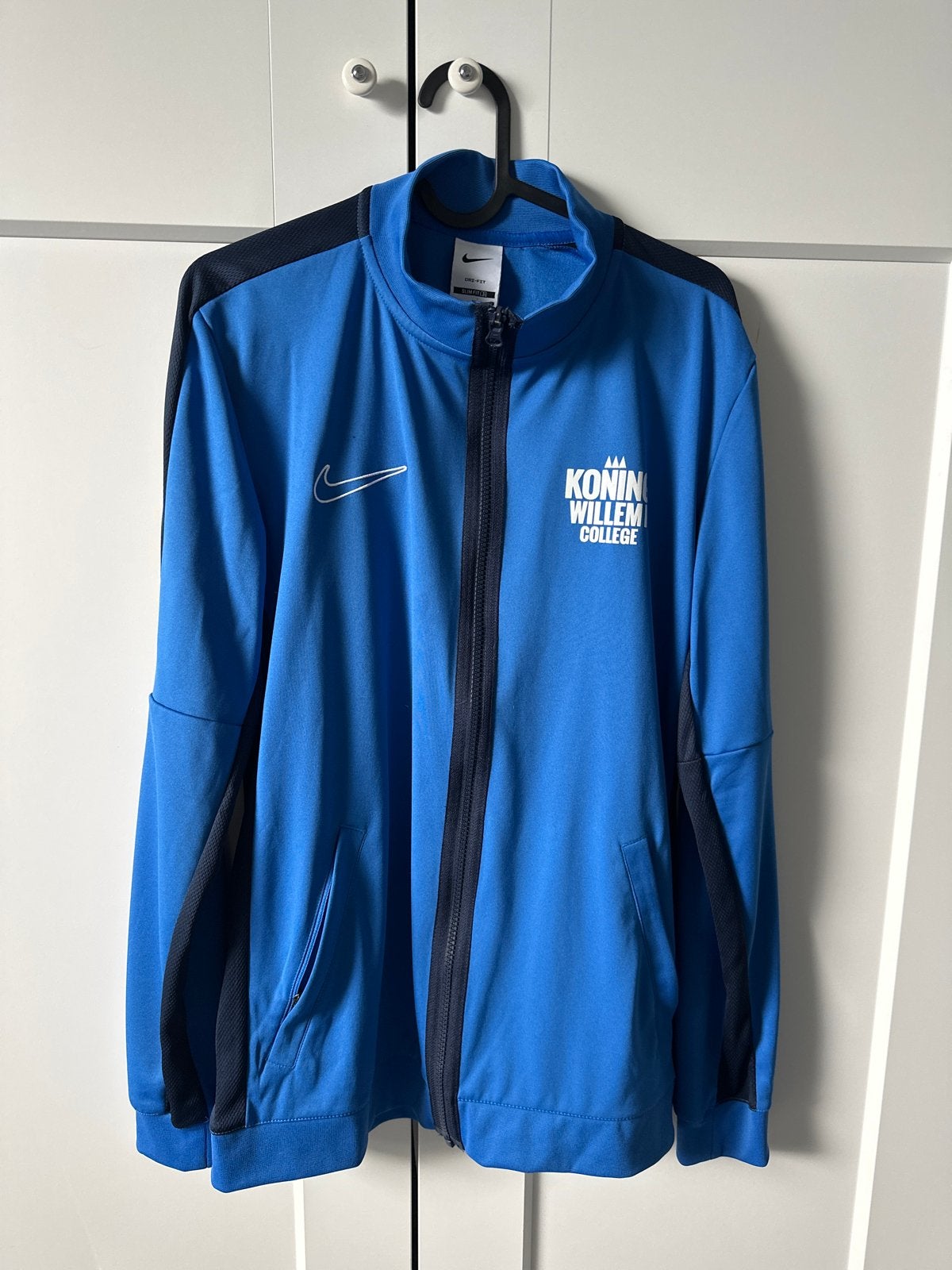 Nike trainingspak (jasje en broek) - Koning Willem College, Zo goed als nieuw, Algemeen, Verzenden, Maat 48/50 (M)
