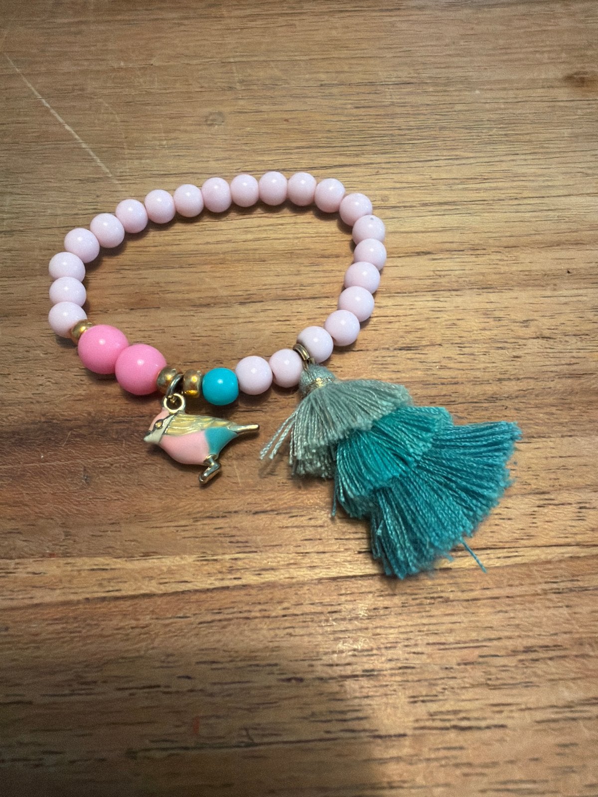 Roze kralenarmband met vogelbedel en kwastje, Overige materialen, Ophalen of Verzenden, Zo goed als nieuw, Roze