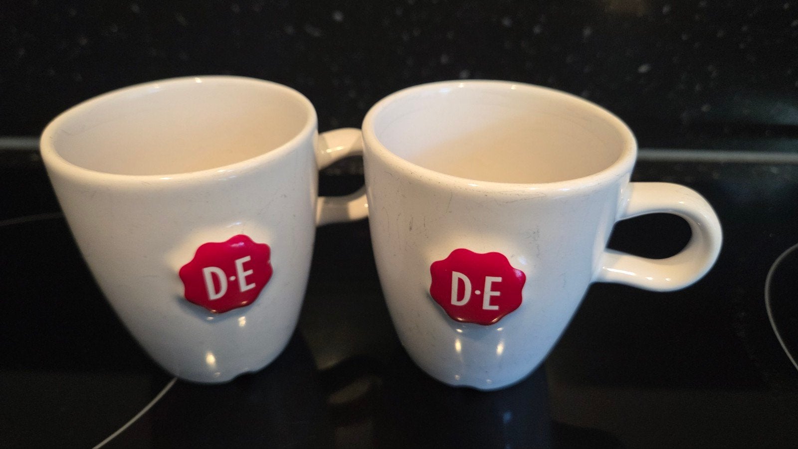 2x Douwe Egberts koffiekopjes - wit met rood logo, Ophalen of Verzenden, Steen/keramiek, Wit, Overige merken