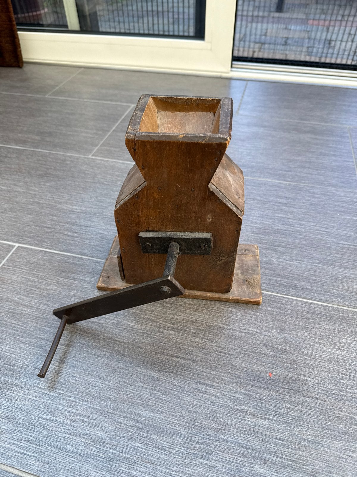Antieke houten graanmolen met slinger, Ophalen
