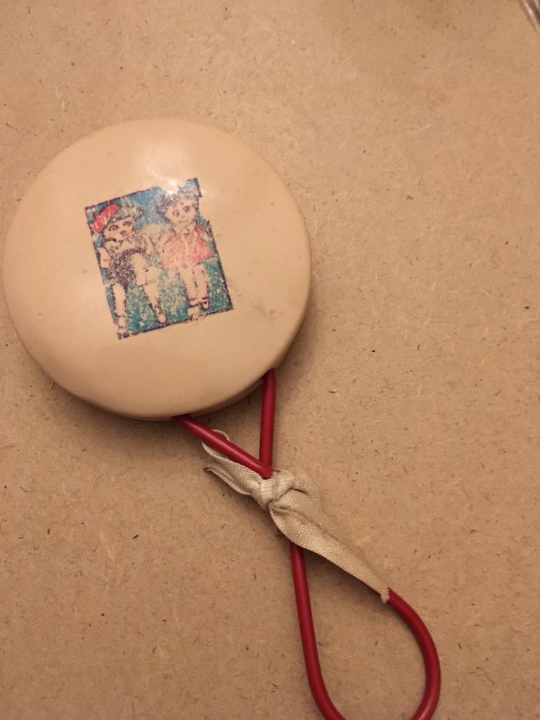 Oude rammelaar met kinderen op afbeelding en oud lintje., Ophalen of Verzenden