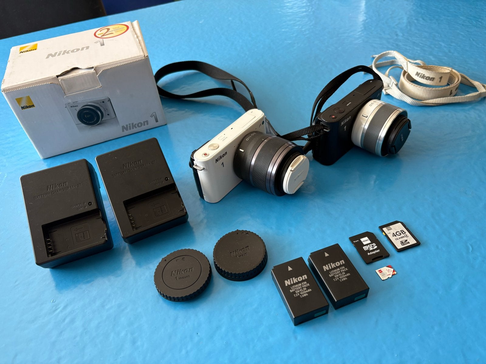 Twee Nikon 1 J1 camera's met twee lenzen en accessoires, Gebruikt, Ophalen of Verzenden, Accu, Nikon