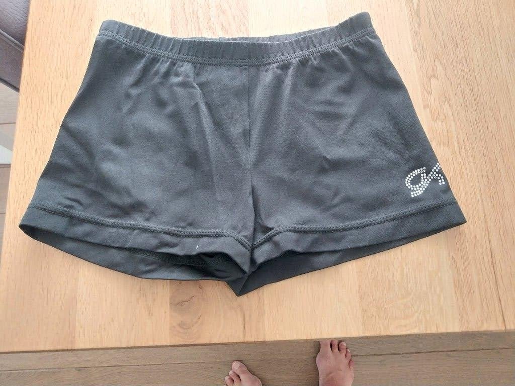 Zwart turnbroekje met strass logo, Sport en Fitness, Ophalen, Gebruikt, Kindermaat 122 t/m 140, Turnbroekje