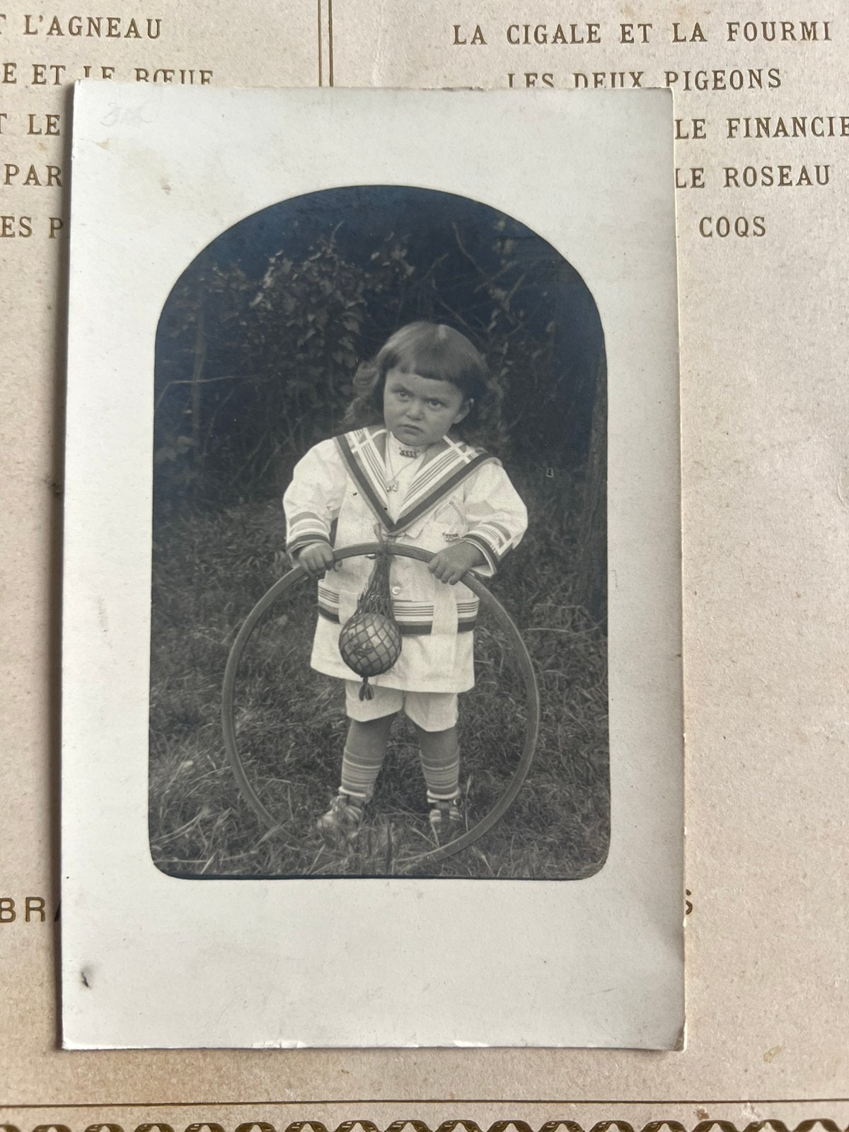 Foto - nors kijkend kindje met hoepel en bal (CW), Gebruikt, Foto, Ophalen of Verzenden, Voor 1940