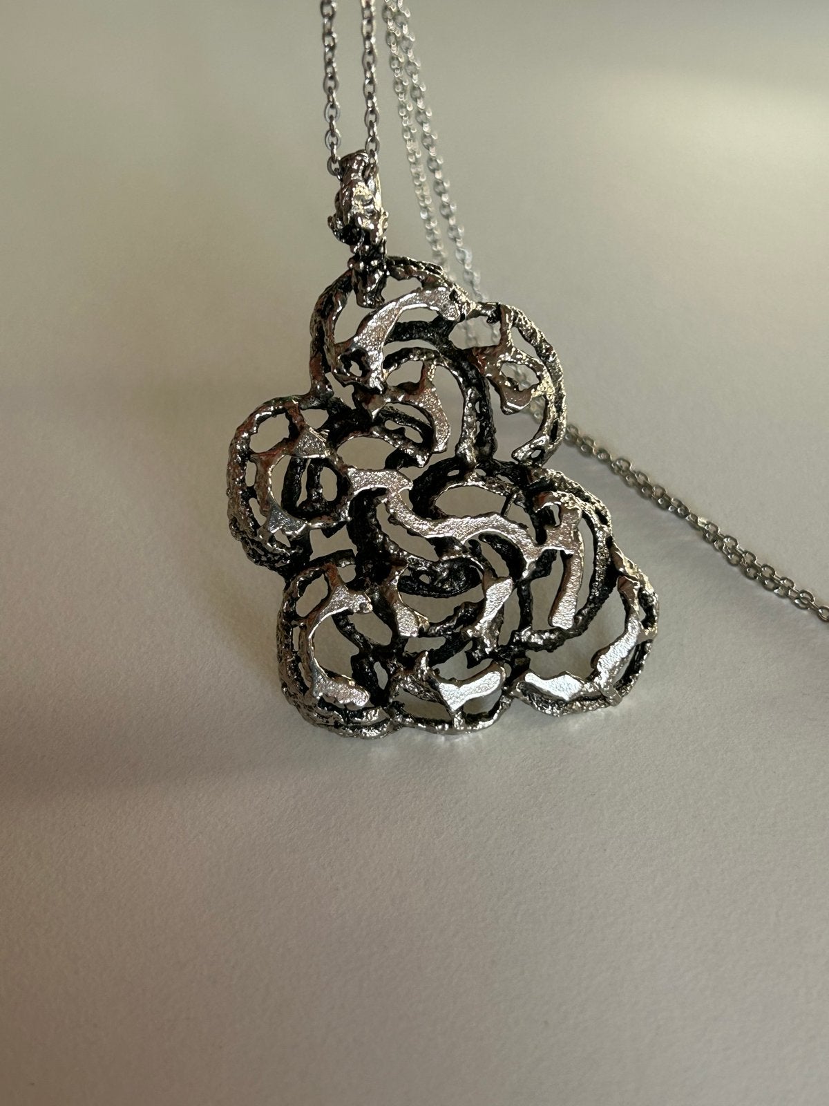 Zilverkleurige ketting met abstracte hanger, Gebruikt, Ophalen of Verzenden, Zilver, Overige materialen
