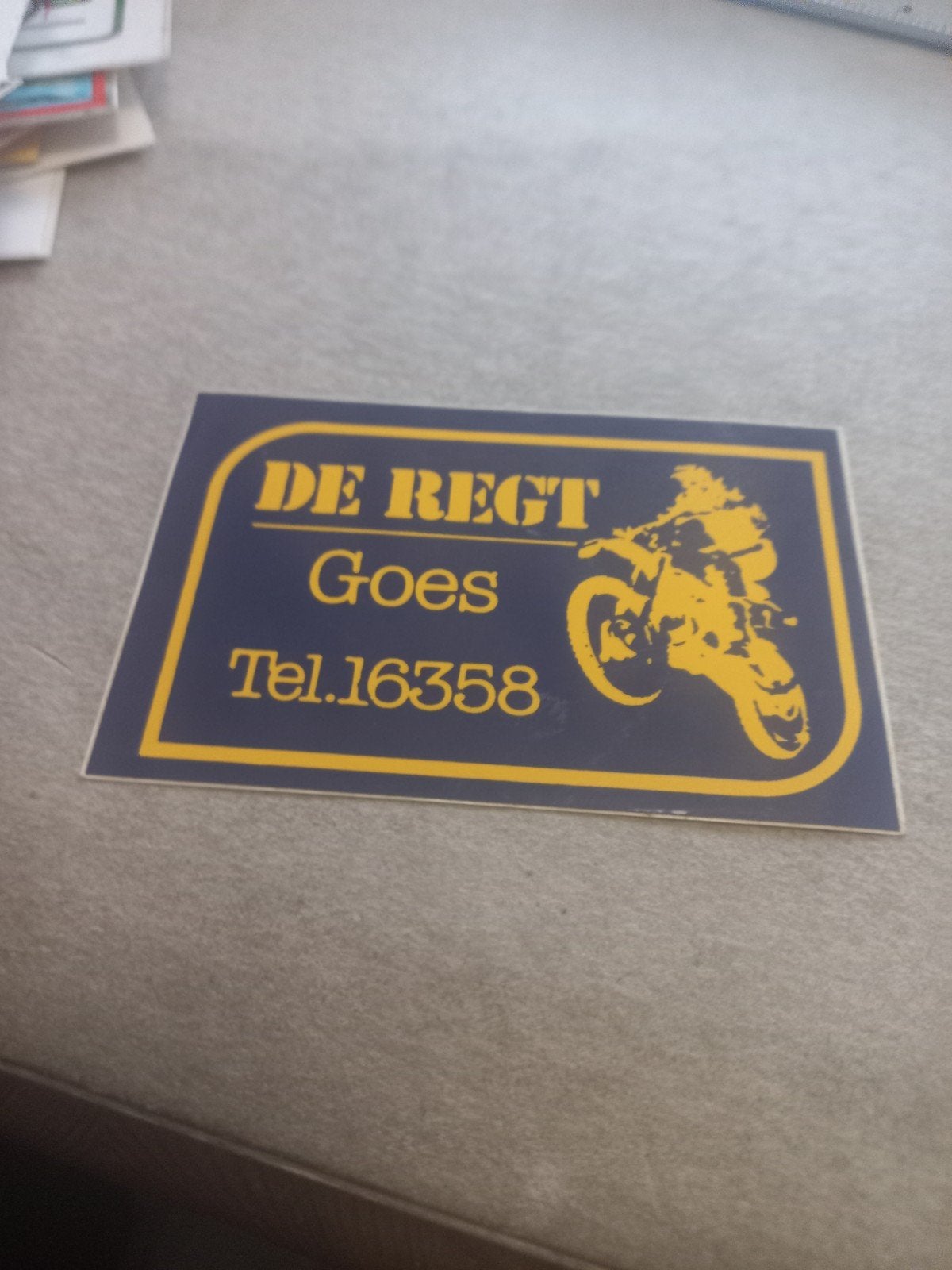 Vintage sticker 'DE REGT Goes Tel.16358' met motor, Ophalen of Verzenden