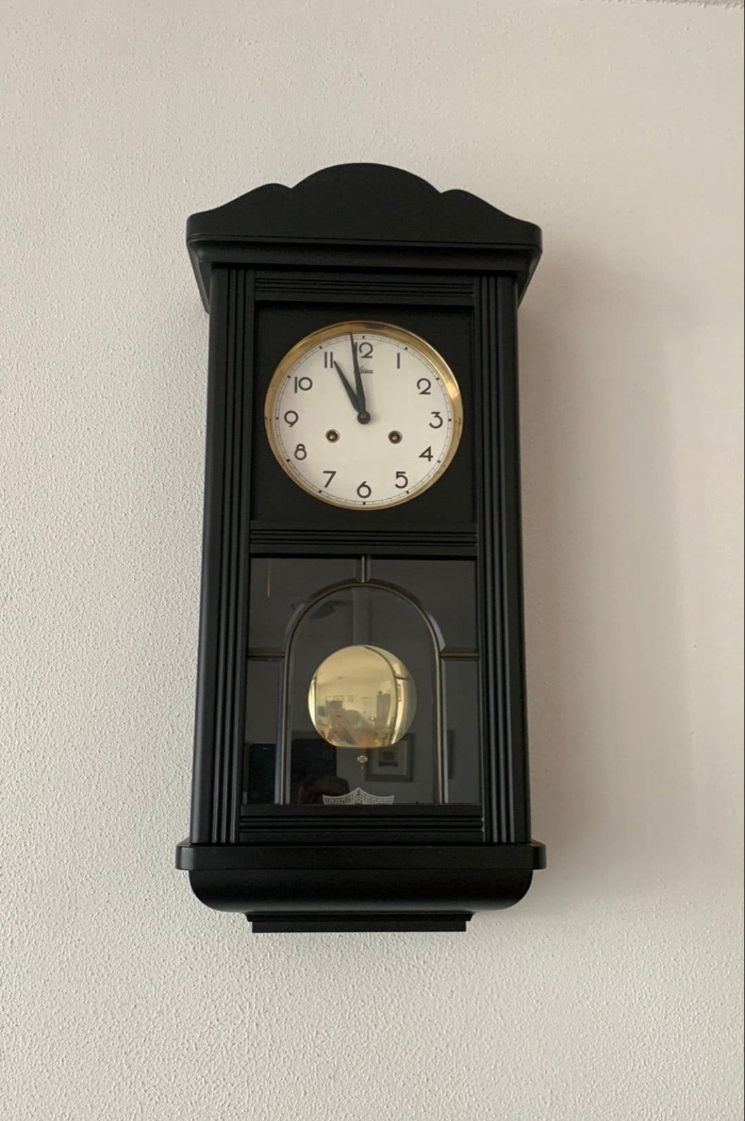 Zwarte wandklok met slinger, Ophalen