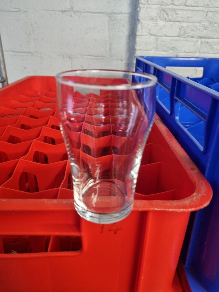 Te koop. Partij kleine cola stapelglazen in kratten, Ophalen, Zo goed als nieuw, Frisdrankglas