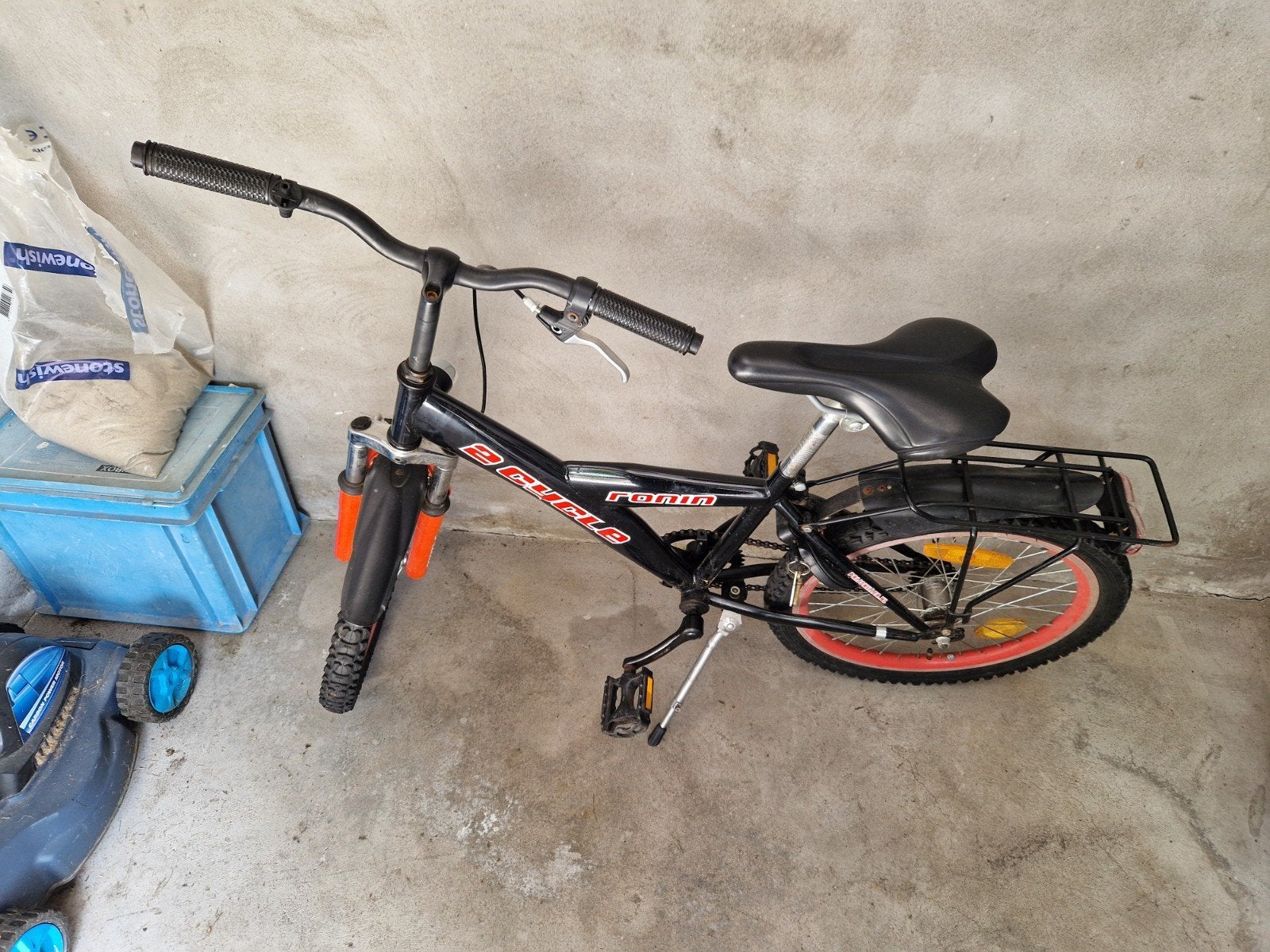 Zwarte kinderfiets met bagagedrager, Ophalen