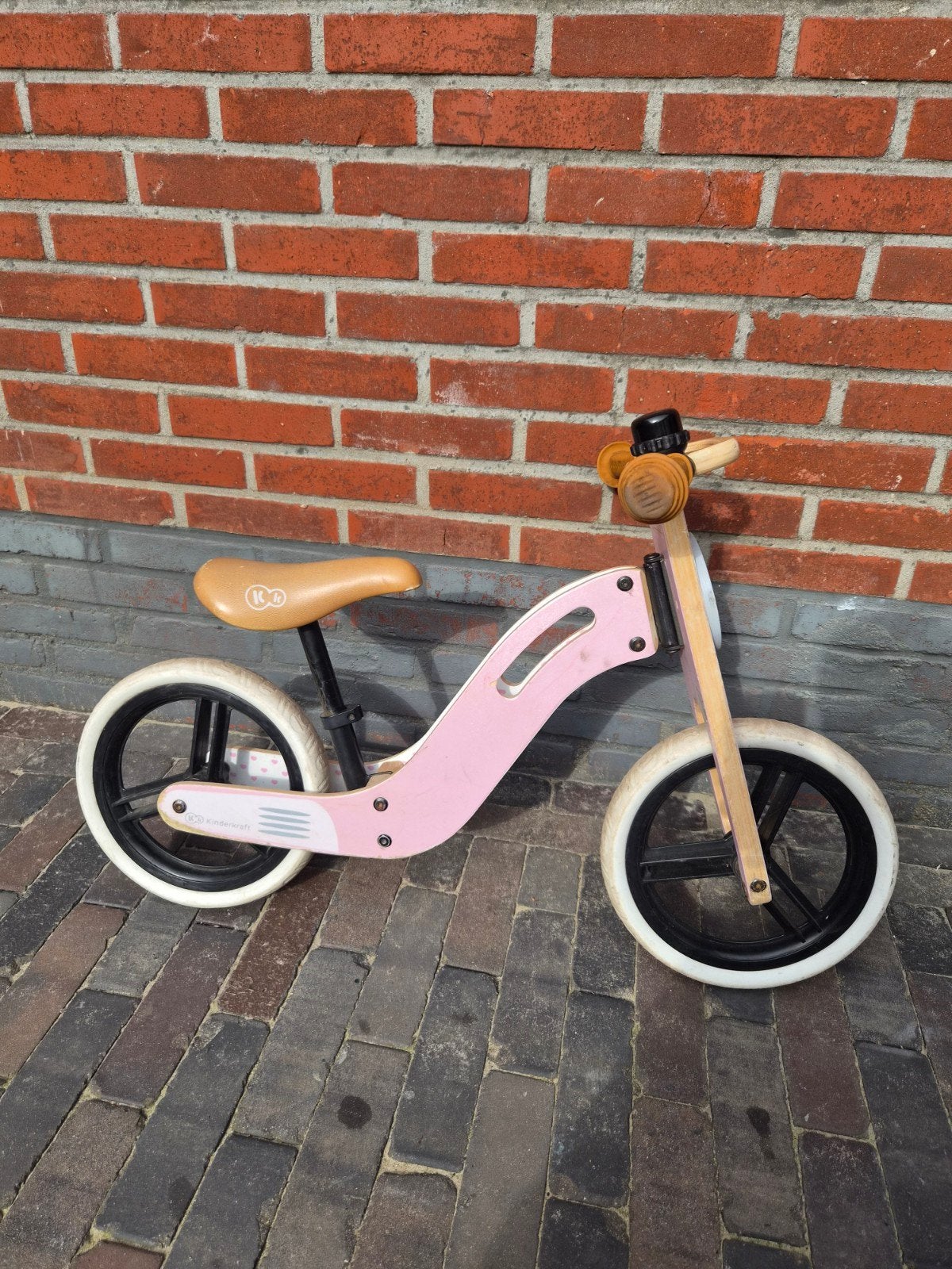 Roze houten loopfiets