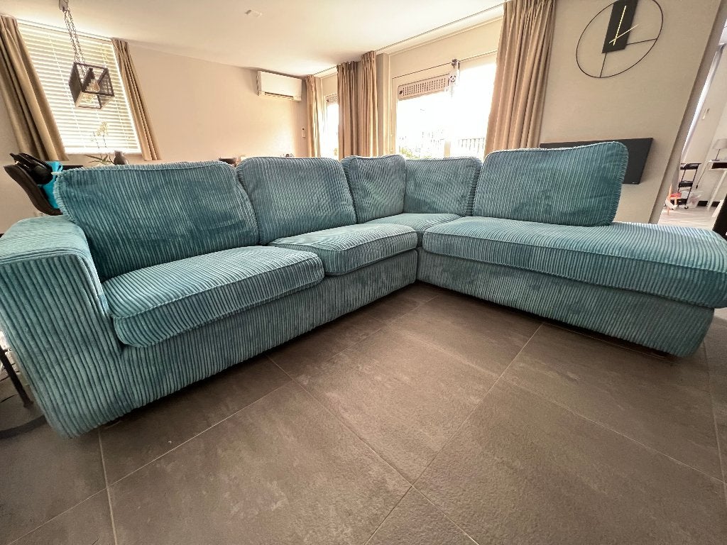 Turquoiseblauwe fluwelen bank met chaise longue.