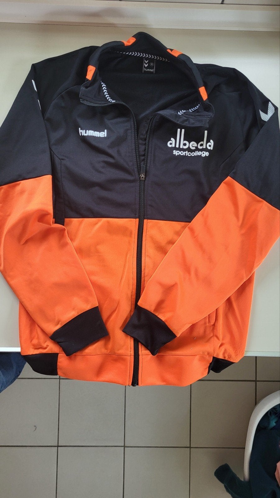 Hummel Sportcollege Trainingsjack Maat M Zwart/Oranje, Maat 48/50 (M), Zwart, Ophalen of Verzenden, Zo goed als nieuw