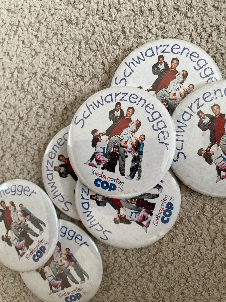 7x Originele film buttons Kindergarten Cop (1990) Arnold, Actiekomedie, Ophalen of Verzenden, Vanaf 12 jaar, Promo