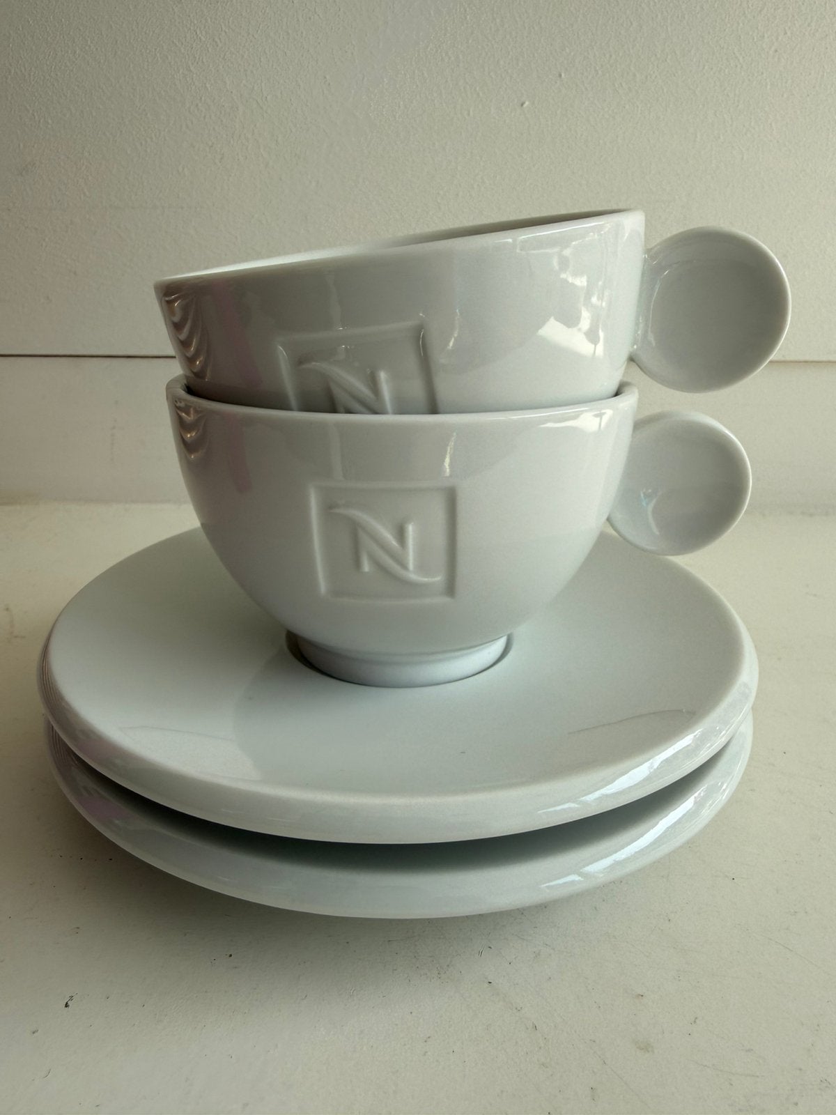 Nespresso wit porseleinen kopjes met schotels set van 2x2, Ophalen of Verzenden, Zo goed als nieuw, Overige stijlen, Kop(pen) en/of Schotel(s)