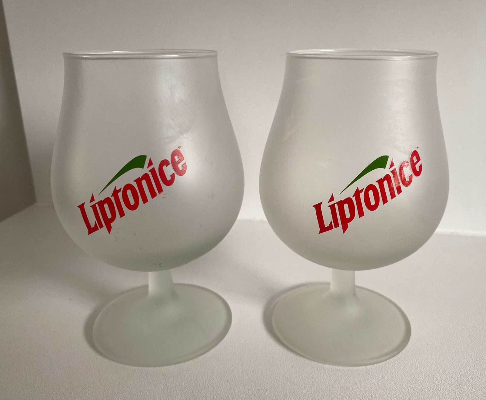 2 Lipton Liptonice glazen op voet. Hoogte 13,5, Ophalen of Verzenden, Zo goed als nieuw, Frisdrankglas