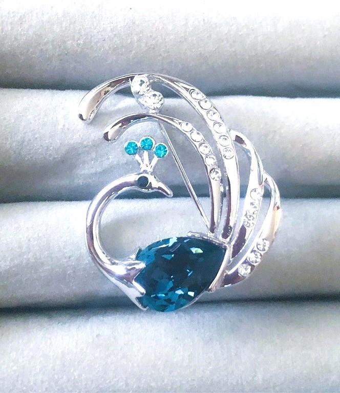 Broche pauw witgoud met kristallen wit en blauw -topaas