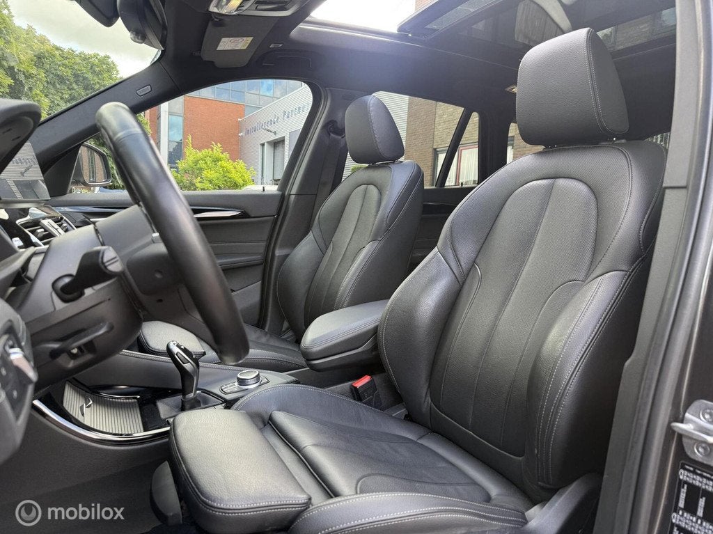 BMW X1 sDrive20i High Executive Panodak Leer Memory Navi Cam, Auto's, BMW, 1998 cc, Zwart, Leder, Bedrijf