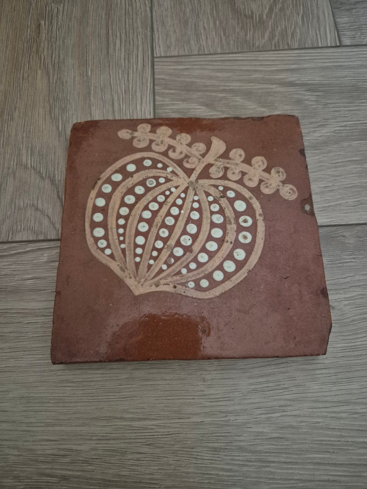 Antieke terracotta tegel met decoratieve appel, Ophalen of Verzenden