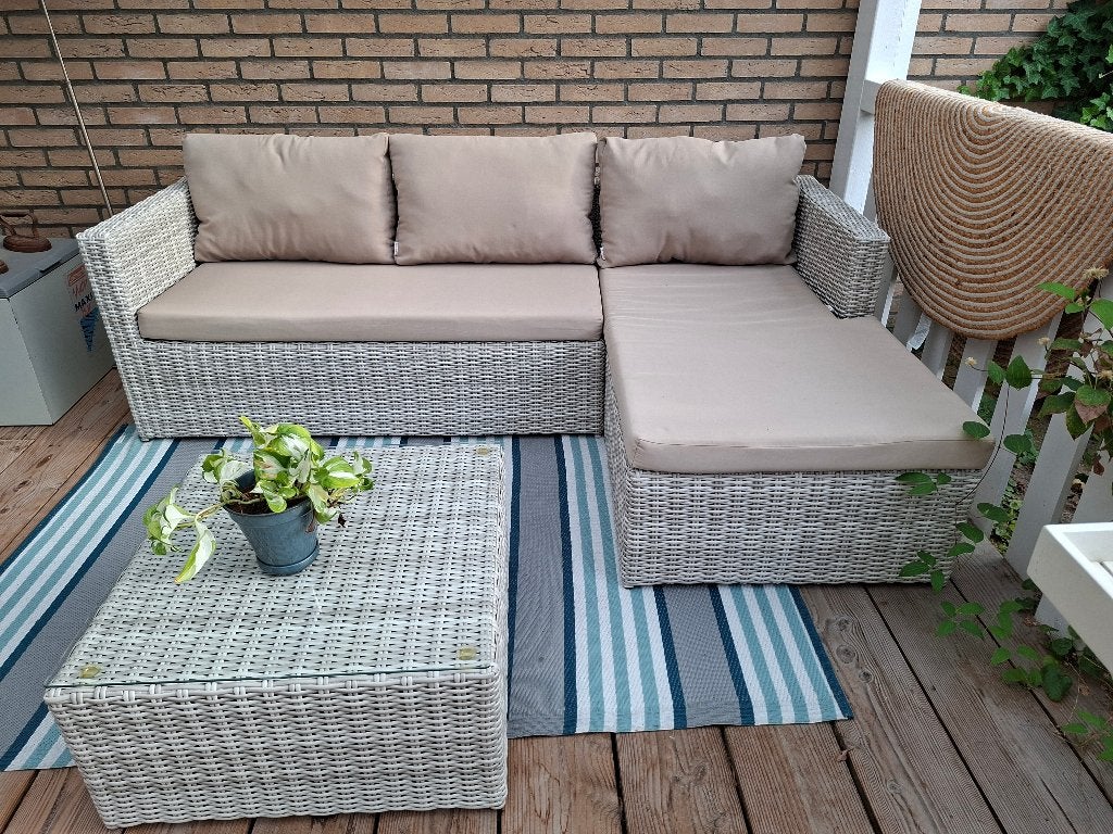 Lounge set met taupekleurige kussens.