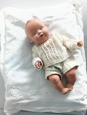 Stenen pop ( 25 cm)liggend op antiek geborduurd kussentje beschikbaar voor biedingen