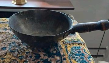 Antieke pan met houten handvat beschikbaar voor biedingen