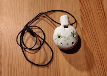 Witte ocarina met groene decoratie beschikbaar voor biedingen