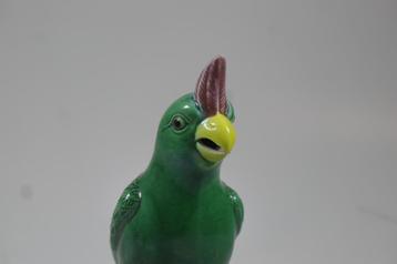 Vintage porseleinen beeld van een groene papegaai. beschikbaar voor biedingen